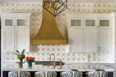 Стильный дизайн: кухня в стиле неоклассика (современная классика) с белыми фасадами, фартуком цвета металлик и островом - последний тренд