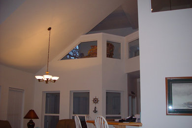 Medium tone wood floor living room photo in Other with white walls, a standard fireplace and a stone fireplace