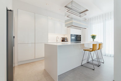 Geschlossene, Zweizeilige, Mittelgroße Moderne Küche mit Unterbauwaschbecken, flächenbündigen Schrankfronten, weißen Schränken, Mineralwerkstoff-Arbeitsplatte, Küchenrückwand in Weiß, Küchengeräten aus Edelstahl, Porzellan-Bodenfliesen, Kücheninsel, grauem Boden, weißer Arbeitsplatte und eingelassener Decke in Sonstige