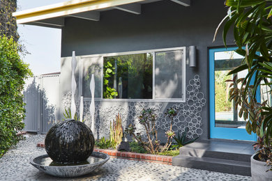 Diseño de fachada de casa gris vintage de tamaño medio de una planta con revestimiento de estuco y tejado plano