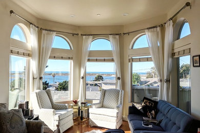 Example of a large trendy open concept medium tone wood floor and brown floor living room library design in San Luis Obispo with beige walls, no fireplace and no tv