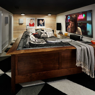 Inspiration pour une petite salle de cinéma bohème fermée avec un mur blanc, béton au sol, un téléviseur fixé au mur et un sol gris.