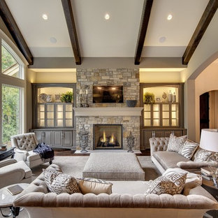 Example of a large classic dark wood floor family room design in Minneapolis with beige walls, a standard fireplace, a stone fireplace and a wall-mounted tv