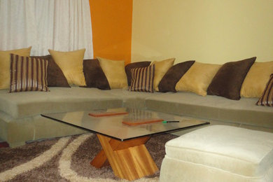 Living room - small modern enclosed carpeted living room idea in Other with orange walls and no fireplace
