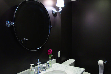 サンフランシスコにあるトランジショナルスタイルのおしゃれなトイレ・洗面所 (大理石の洗面台、白いタイル、黒い壁、大理石の床) の写真