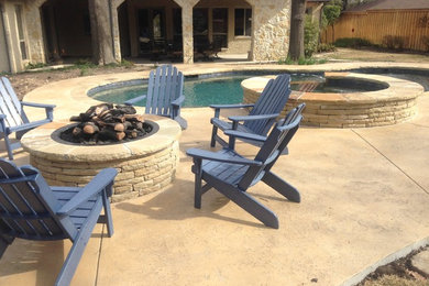 Photo of a large country backyard custom-shaped natural pool in Dallas with a hot tub and stamped concrete.
