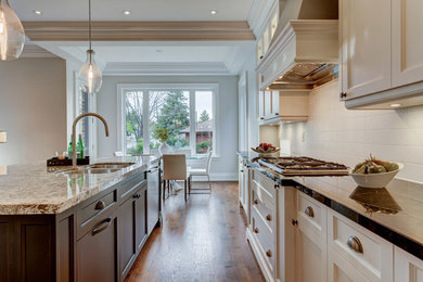 Inspiration for a mid-sized transitional l-shaped open plan kitchen in Toronto with an undermount sink, shaker cabinets, white cabinets, granite benchtops, white splashback, ceramic splashback, stainless steel appliances, dark hardwood floors and with island.