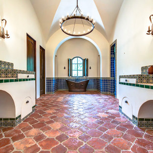 Cette image montre une salle de bain principale chalet de taille moyenne avec une vasque, un plan de toilette en carrelage, une baignoire indépendante, une douche double, un carrelage vert, des carreaux en terre cuite, un mur beige et un sol en carreau de terre cuite.