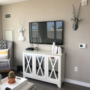 Idee per un piccolo soggiorno minimalista aperto con libreria, pareti beige, pavimento in laminato, TV a parete e pavimento grigio