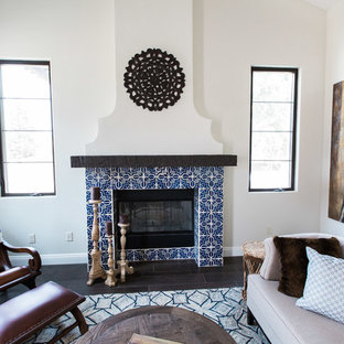 Mittelgroßes, Repräsentatives, Offenes Mediterranes Wohnzimmer mit beiger Wandfarbe, dunklem Holzboden, Kamin, gefliestem Kaminsims, freistehendem TV und braunem Boden in Sonstige
