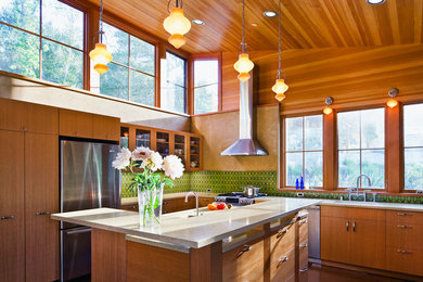 Inspiration for a contemporary concrete floor open concept kitchen remodel in San Francisco with an undermount sink, flat-panel cabinets, medium tone wood cabinets, recycled glass countertops, green backsplash, ceramic backsplash, stainless steel appliances and an island