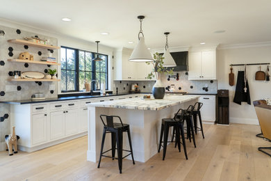 Inspiration for a large transitional l-shaped light wood floor eat-in kitchen remodel in New York with shaker cabinets, white cabinets, marble countertops, porcelain backsplash, an island and multicolored countertops