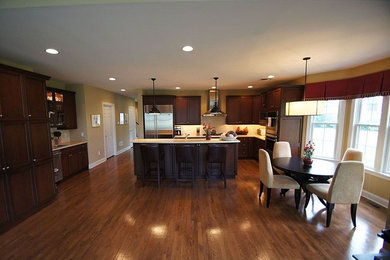 Open concept kitchen - traditional l-shaped medium tone wood floor open concept kitchen idea in New York with dark wood cabinets, stainless steel appliances and an island