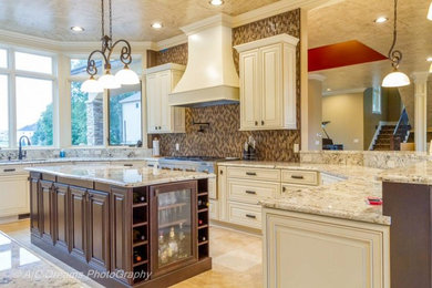 Inspiration for a large transitional u-shaped eat-in kitchen in Grand Rapids with an undermount sink, raised-panel cabinets, granite benchtops, stainless steel appliances, multi-coloured splashback, mosaic tile splashback, distressed cabinets, porcelain floors and multiple islands.