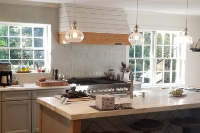 Inspiration for a mid-sized country gray floor kitchen remodel in Atlanta with a farmhouse sink, shaker cabinets, terra-cotta backsplash, stainless steel appliances and white countertops
