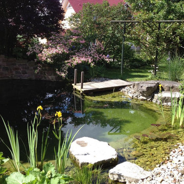 Kleiner Schwimmteich mit Wasserfall, Steg und Stegterrasse