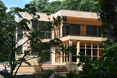 Example of a large trendy beige two-story wood exterior home design in New York