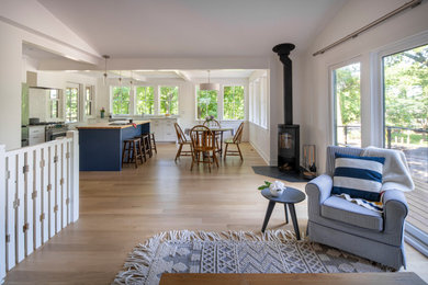 Inspiration for a contemporary open concept living room remodel in Minneapolis with a wood stove and a stone fireplace