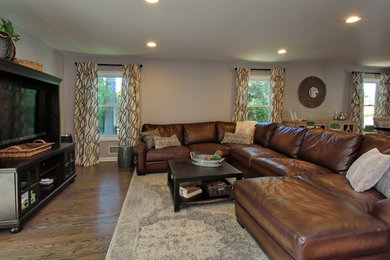 Living room - mid-sized transitional formal and open concept medium tone wood floor living room idea in New York with gray walls, no fireplace and a media wall
