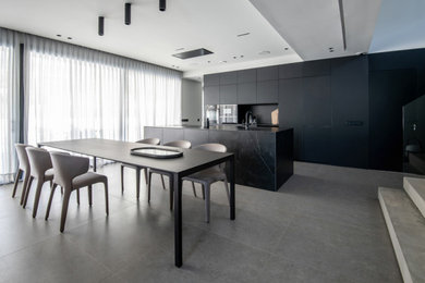Photo of a large modern single-wall open plan kitchen in Barcelona with a submerged sink, flat-panel cabinets, black cabinets, black splashback, black appliances, an island, grey floors and black worktops.