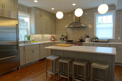 Open concept kitchen - mid-sized contemporary l-shaped dark wood floor and brown floor open concept kitchen idea in Chicago with shaker cabinets, subway tile backsplash, stainless steel appliances, an island, an undermount sink, gray cabinets and gray backsplash