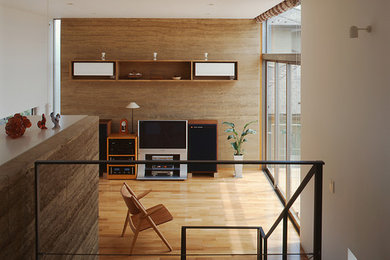 Large modern open concept living room in Tokyo Suburbs with beige walls, medium hardwood floors, a freestanding tv and beige floor.