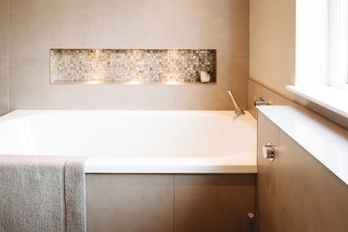 This is an example of a small contemporary ensuite bathroom in Sussex with beige tiles, porcelain tiles and beige walls.