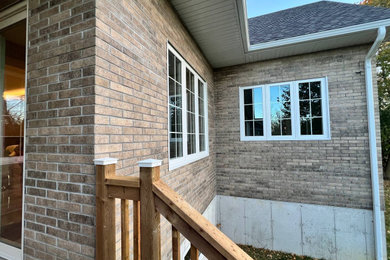Mid-sized traditional beige one-story brick and shingle exterior home idea in Toronto