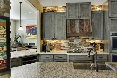 Inspiration for a mid-sized transitional galley open plan kitchen in Denver with a farmhouse sink, shaker cabinets, dark wood cabinets, granite benchtops, beige splashback, stone tile splashback, stainless steel appliances, medium hardwood floors, a peninsula, brown floor and beige benchtop.