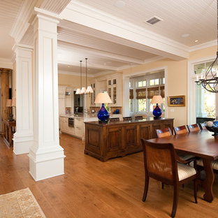 На фото: с высоким бюджетом большие гостиные-столовые в классическом стиле с желтыми стенами, паркетным полом среднего тона и стандартным камином