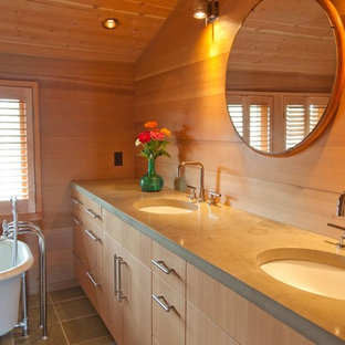 Großes Maritimes Badezimmer En Suite mit Einbauwaschbecken, flächenbündigen Schrankfronten, hellen Holzschränken, Eckbadewanne, grauen Fliesen, beiger Wandfarbe, Keramikboden und Beton-Waschbecken/Waschtisch in Boston