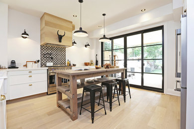 Large danish light wood floor open concept kitchen photo in Toronto with a farmhouse sink, flat-panel cabinets, white cabinets, quartzite countertops, multicolored backsplash, ceramic backsplash, stainless steel appliances and an island