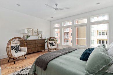 Imagen de dormitorio principal minimalista de tamaño medio con paredes blancas, suelo de madera clara y suelo marrón