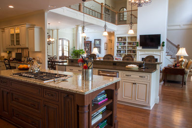 Large elegant galley medium tone wood floor open concept kitchen photo with raised-panel cabinets, white cabinets, granite countertops, stainless steel appliances and two islands