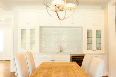 Example of a large transitional medium tone wood floor eat-in kitchen design in Portland with recessed-panel cabinets, white cabinets, white backsplash, glass tile backsplash and stainless steel appliances