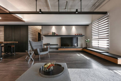 Imagen de salón tipo loft actual grande con paredes grises, suelo de madera oscura, chimenea de doble cara, televisor independiente y suelo marrón
