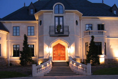 Huge traditional gray three-story stucco exterior home idea in Philadelphia