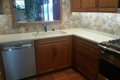 Enclosed kitchen - mid-sized transitional u-shaped porcelain tile and beige floor enclosed kitchen idea in San Diego with an undermount sink, raised-panel cabinets, medium tone wood cabinets, quartz countertops, beige backsplash, porcelain backsplash, stainless steel appliances and a peninsula