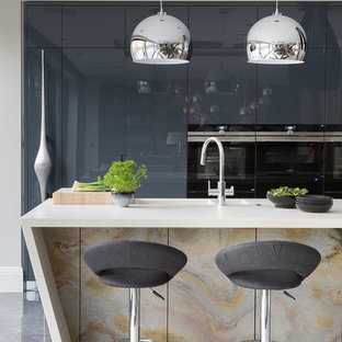 Large contemporary kitchen pantry pictures - Inspiration for a large contemporary galley porcelain floor and gray floor kitchen pantry remodel in Hertfordshire with an undermount sink, flat-panel cabinets, distressed cabinets, quartzite countertops, black appliances, an island and white countertops