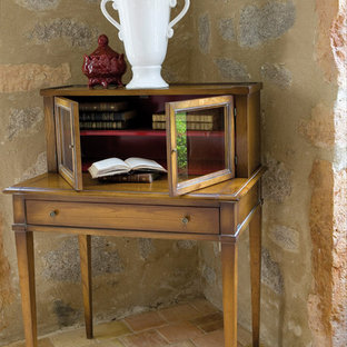 Imagen de biblioteca en casa abierta, mediterránea, de tamaño medio, sin chimenea, con paredes negras, suelo de madera clara, marco de chimenea de piedra, pared multimedia y suelo gris