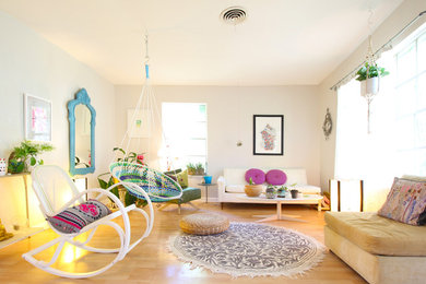 Example of an eclectic light wood floor living room design with white walls and no fireplace