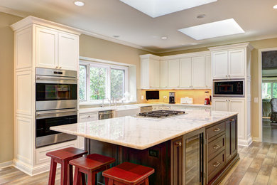 Example of a large transitional u-shaped kitchen design in Chicago with recessed-panel cabinets, white cabinets and an island