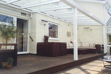 Photo of a large contemporary back screened veranda in Devon with decking and a roof extension.