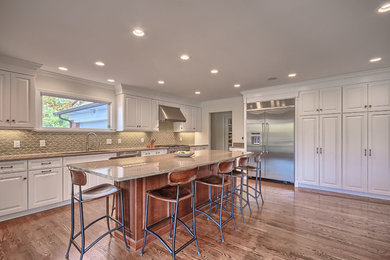 Inspiration for a huge timeless l-shaped dark wood floor open concept kitchen remodel in St Louis with an undermount sink, raised-panel cabinets, white cabinets, granite countertops, green backsplash, ceramic backsplash, white appliances and an island