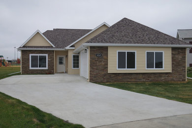 Example of a mid-sized yellow one-story mixed siding exterior home design in Other