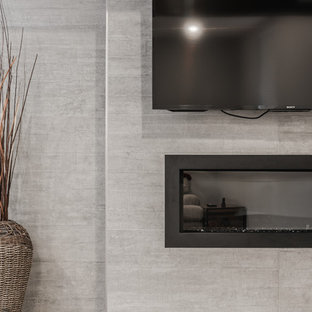 Photo of a large traditional look-out basement in Toronto with grey walls, vinyl flooring, a hanging fireplace, a concrete fireplace surround and brown floors.