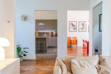 Immagine di un soggiorno contemporaneo di medie dimensioni e aperto con libreria, pareti beige, TV nascosta e con abbinamento di divani diversi