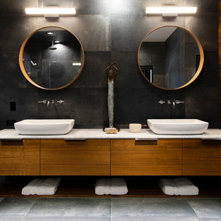 Inspiration for a large contemporary master black tile and porcelain tile porcelain floor and gray floor bathroom remodel in Omaha with flat-panel cabinets, black walls, a vessel sink, marble countertops, white countertops and medium tone wood cabinets