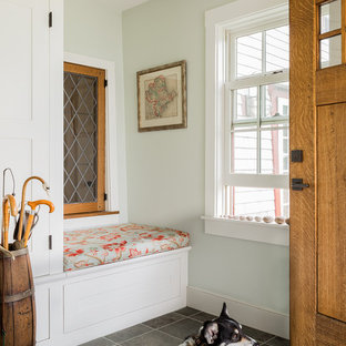 ボストンの片開きドアトラディショナルスタイルのおしゃれな玄関 (緑の壁、木目調のドア、グレーの床) の写真