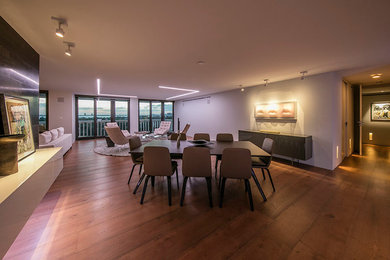 Great room - mid-sized contemporary medium tone wood floor and brown floor great room idea in Miami with gray walls and no fireplace